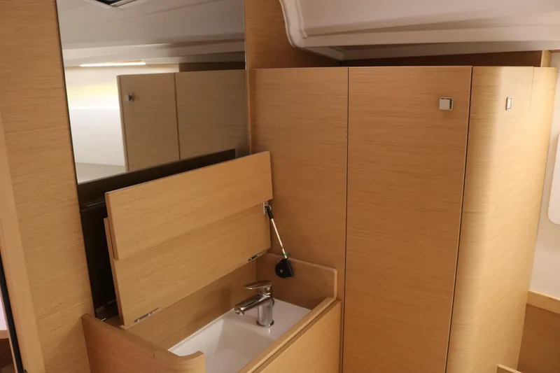 Slide: The Image of Modern bathroom interior of 2026 Jeanneau Sun Odyssey 415 yacht, featuring sleek wooden cabinetry. - 45