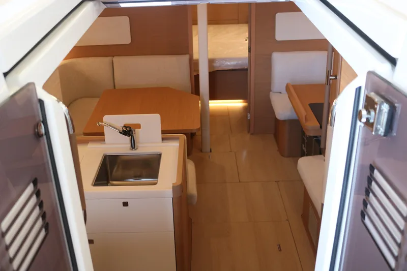 Slide: The Image of Interior of 2026 Jeanneau Sun Odyssey 415 yacht, featuring modern kitchen and cozy seating area. - 26