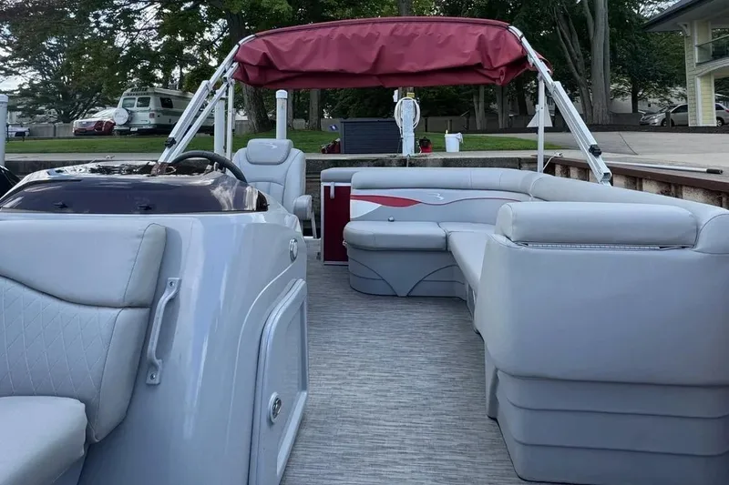 Slide: The Image of 2022 Bennington 198SL pontoon boat with red canopy and spacious seating. - 12