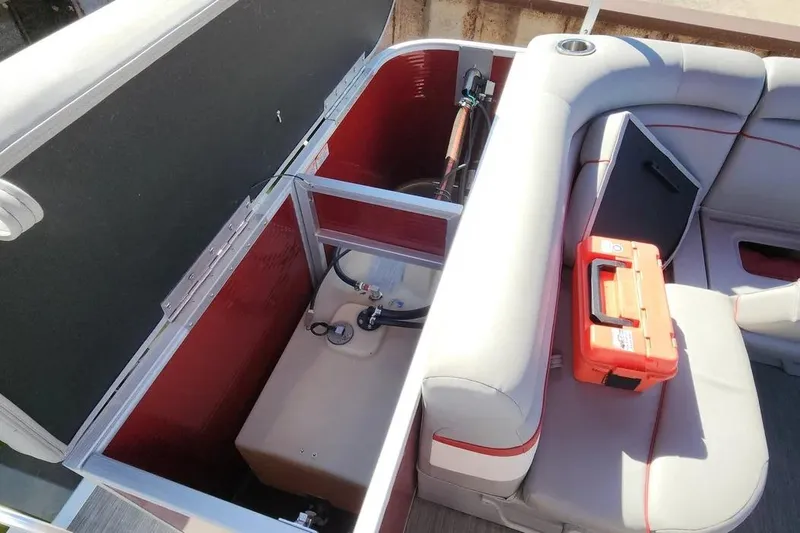 Slide: The Image of 2022 Bennington 198SL boat interior storage compartment with seating and orange toolbox. - 16