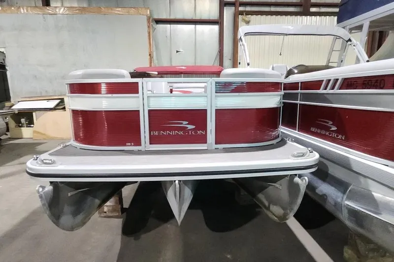 Slide: The Image of 2022 Bennington 198SL pontoon boat in a storage facility, featuring red and white design. - 18