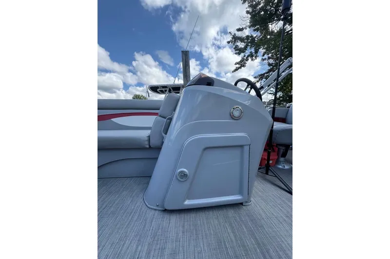 Slide: The Image of 2022 Bennington 198SL boat console with steering wheel, under a partly cloudy sky. - 29