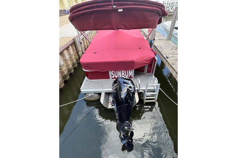 Slide: The Image of 2022 Bennington 198SL pontoon boat with red canopy docked at marina. - 3