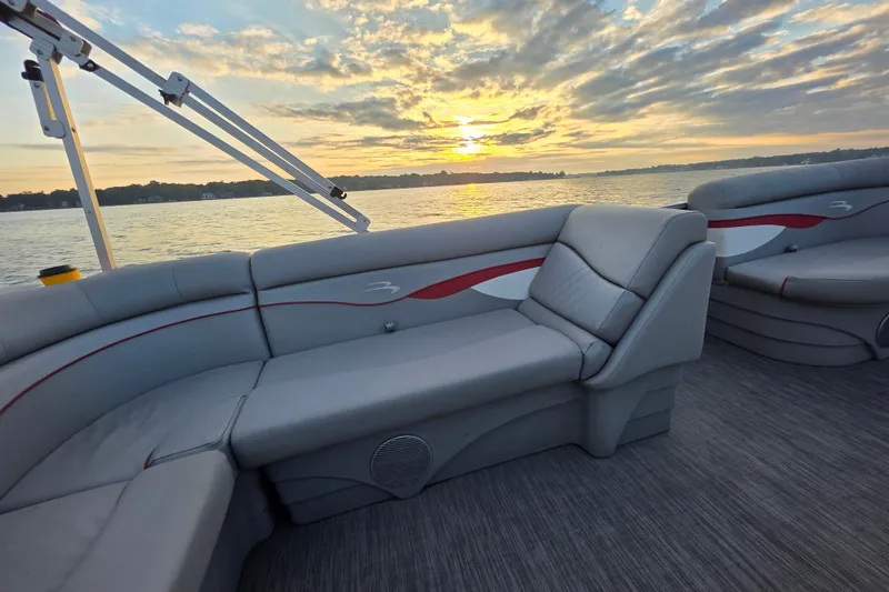 Slide: The Image of 2022 Bennington 198SL pontoon boat interior at sunset on a serene lake. - 31