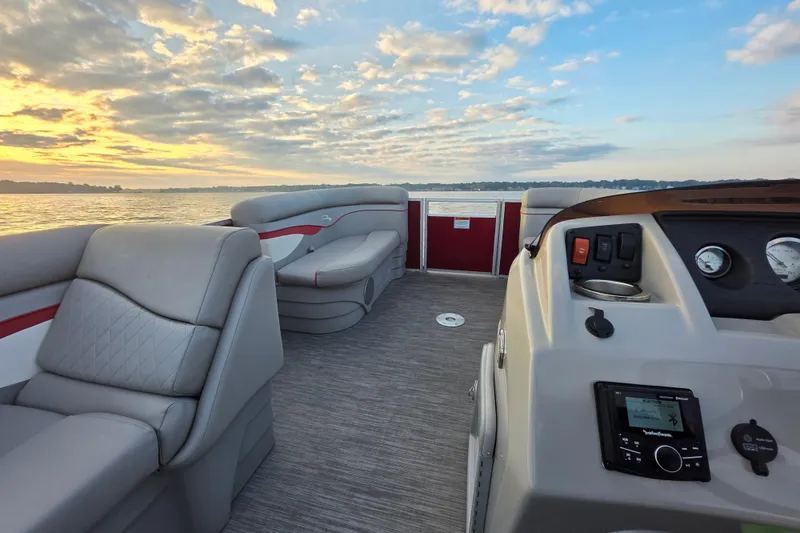 Slide: The Image of 2022 Bennington 198SL pontoon boat interior at sunset on a serene lake. - 32