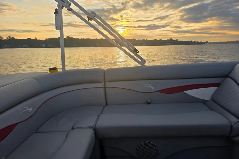 Slide: The Image of 2022 Bennington 198SL pontoon boat interior at sunset on a serene lake. - 35