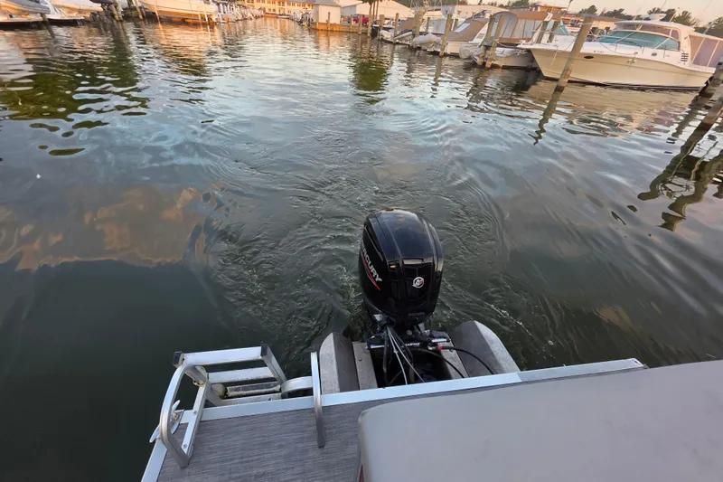 Slide: The Image of 2022 Bennington 198SL pontoon boat with Mercury outboard motor in a marina setting. - 42