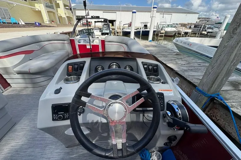 Slide: The Image of 2022 Bennington 198SL boat dashboard with steering wheel, docked at marina. - 6