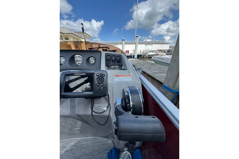Slide: The Image of 2022 Bennington 198SL boat dashboard with Lowrance navigation system at a dock. - 8
