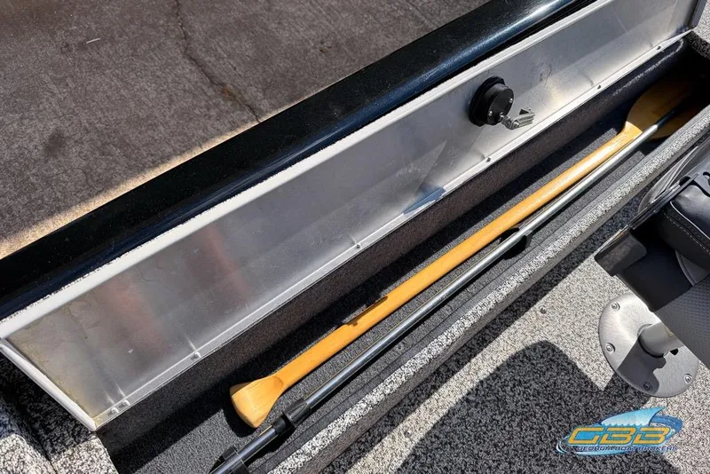 Slide: The Image of 2015 Tracker Super Guide V-16 SC boat storage compartment with paddle and rod. - 12