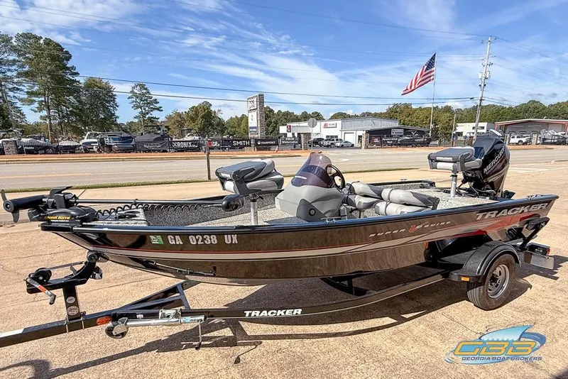 Slide: The Image of 2015 Tracker Super Guide V-16 SC fishing boat on trailer, parked outdoors. - 3