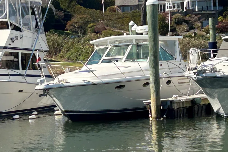 Slide: The Image of 1993 Tiara Yachts 3100 Open docked at marina, surrounded by other boats. - 1