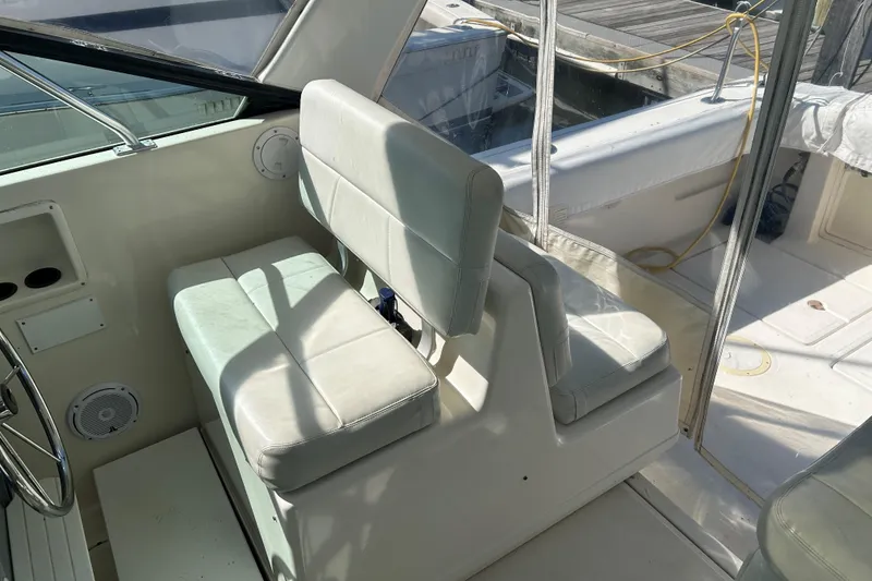 Slide: The Image of 1993 Tiara Yachts 3100 Open interior with white seating and steering wheel. - 10
