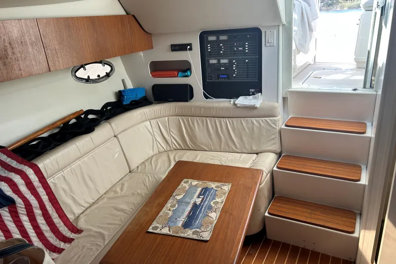 Slide: The Image of 1993 Tiara Yachts 3100 Open interior with leather seating, wooden table, and stairs. - 13