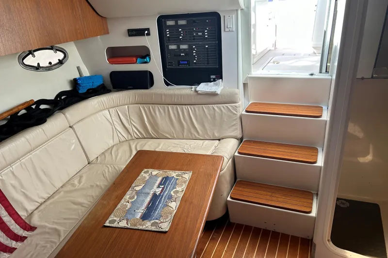 Slide: The Image of Interior of a 1993 Tiara Yachts 3100 Open, featuring a cozy seating area and wooden steps. - 14