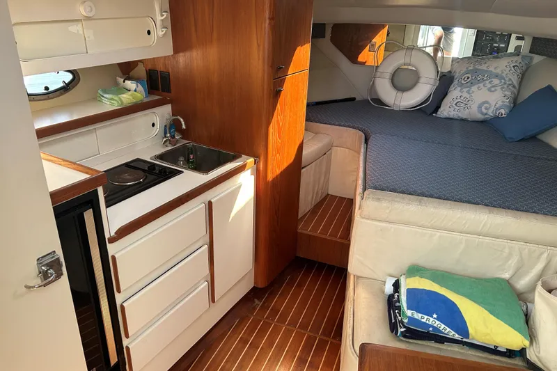 Slide: The Image of 1993 Tiara Yachts 3100 Open interior with kitchenette, bed, and wooden flooring. - 16