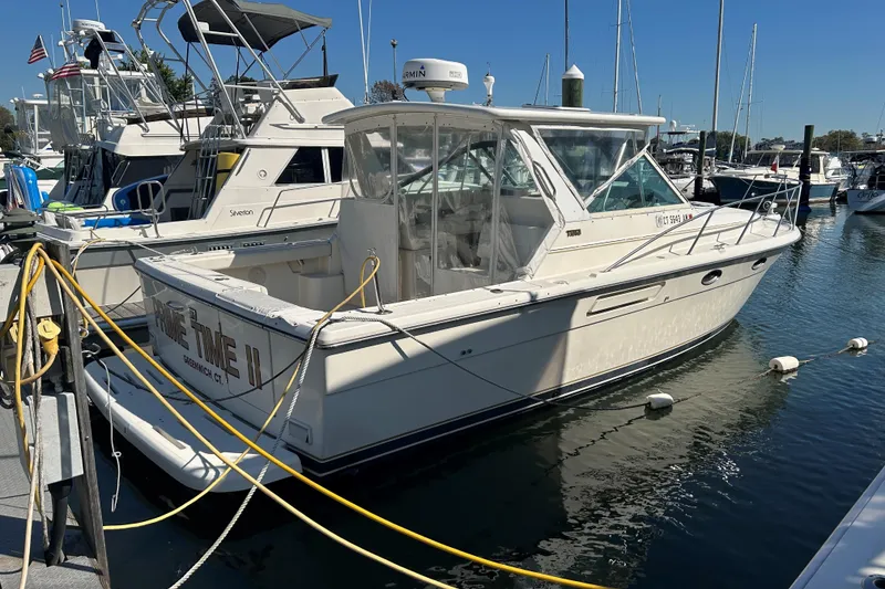 Slide: The Image of 1993 Tiara Yachts 3100 Open docked at marina, side view. - 2