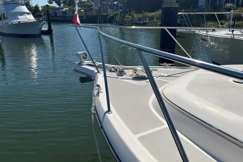 Slide: The Image of 1993 Tiara Yachts 3100 Open docked in a serene marina setting. - 25