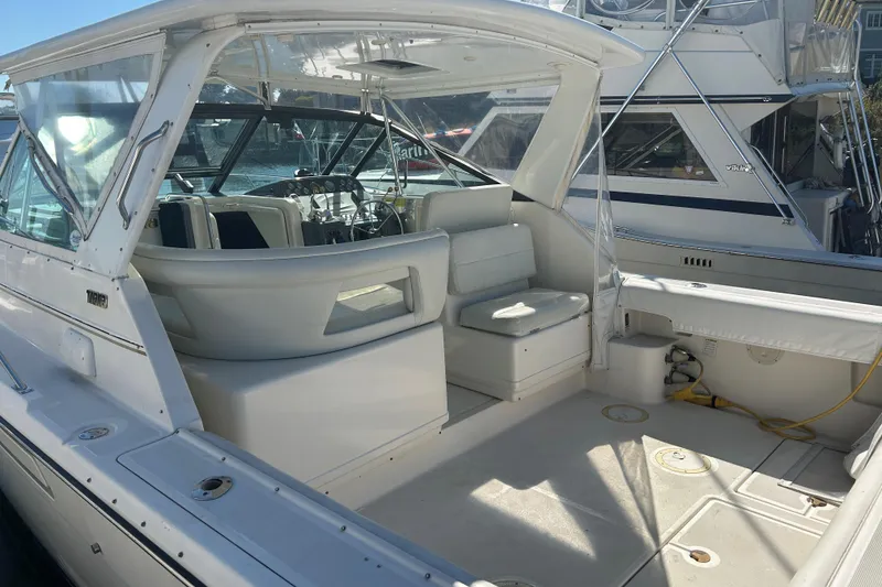 Slide: The Image of 1993 Tiara Yachts 3100 Open boat interior with seating and helm, docked at marina. - 3