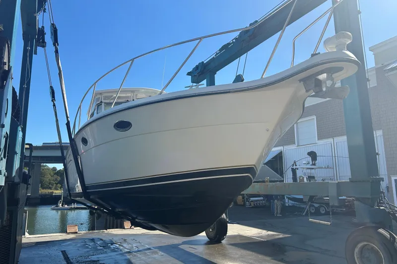 Slide: The Image of 1993 Tiara Yachts 3100 Open boat lifted in a marina setting. - 31