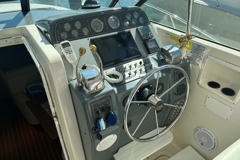 Slide: The Image of 1993 Tiara Yachts 3100 Open helm with steering wheel and control panel. - 5