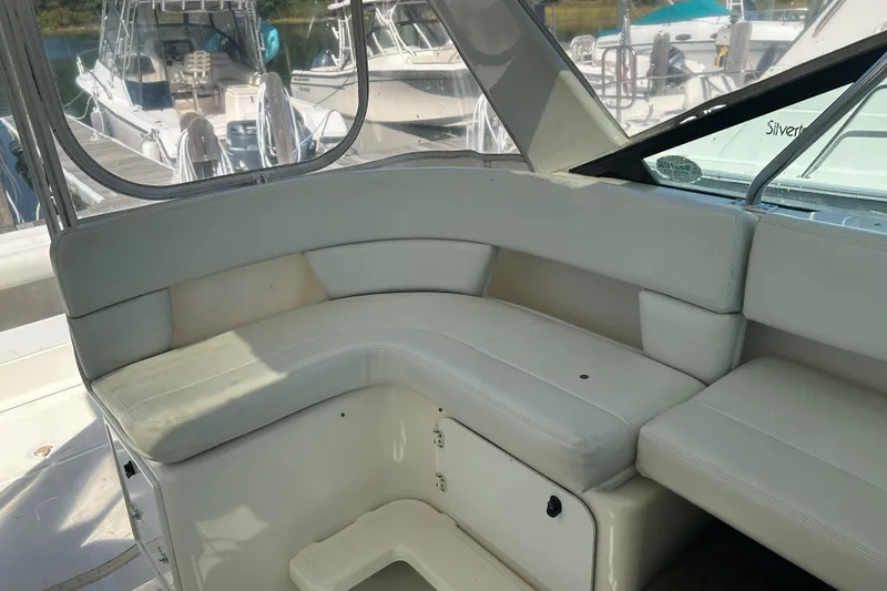 Slide: The Image of 1993 Tiara Yachts 3100 Open interior with white seating and docked boats in background. - 8