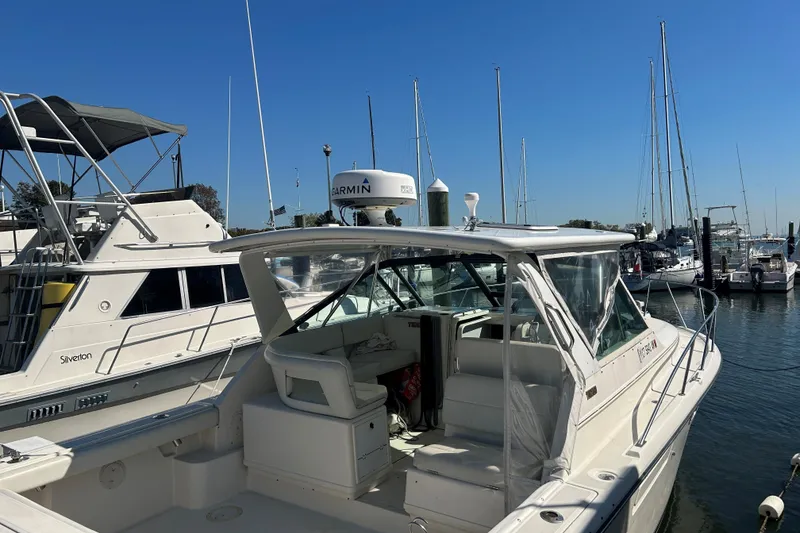 Slide: The Image of 1993 Tiara Yachts 3100 Open docked at marina, clear sky, multiple boats in background. - 9