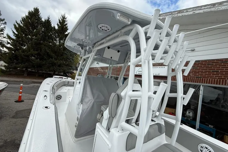 Slide: The Image of 2025 Cape Horn 34 XS boat with rod holders and T-top, parked outdoors. - 18