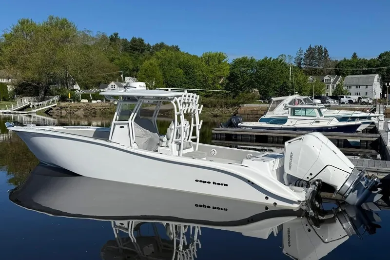 Slide: The Image of 2025 Cape Horn 34 XS boat docked on calm water, surrounded by greenery and other boats. - 13