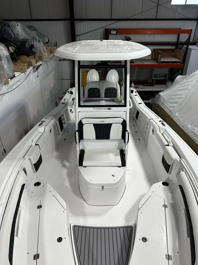 Slide: The Image of 2024 Tidewater 272 LXF boat with spacious seating and modern design in a storage facility. - 16