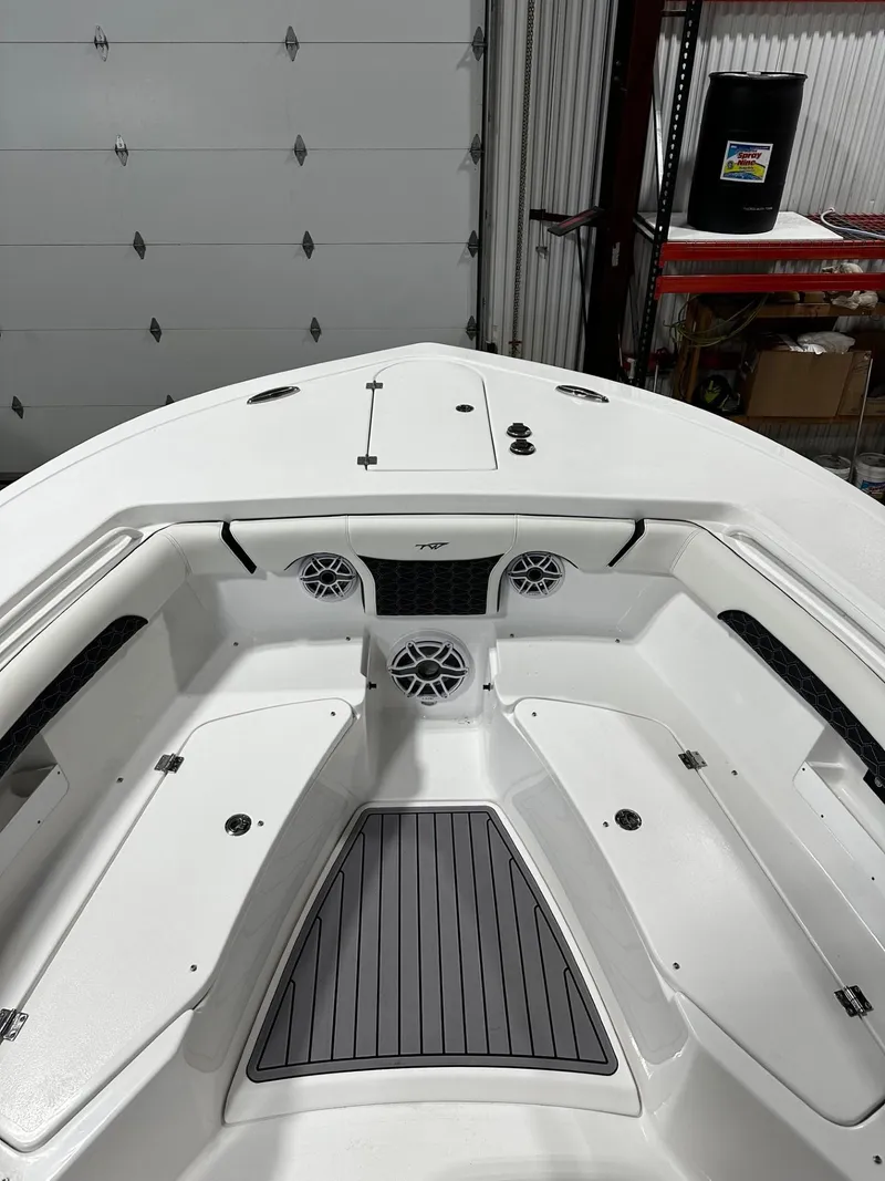 Slide: The Image of 2024 Tidewater 272 LXF boat interior with seating and speakers in a garage setting. - 19
