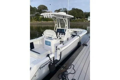 Slide: The Image of 2024 Tidewater 272 LXF boat docked by a serene waterfront. - 2