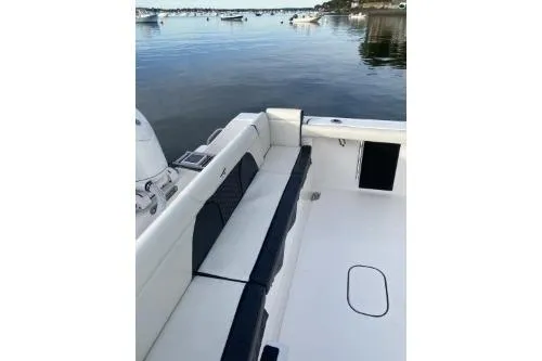 Slide: The Image of 2024 Tidewater 272 LXF boat interior with seating, docked on calm water. - 8