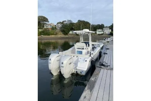 Slide: The Image of 2024 Tidewater 272 LXF boat docked with dual engines in a serene waterfront setting. - 9