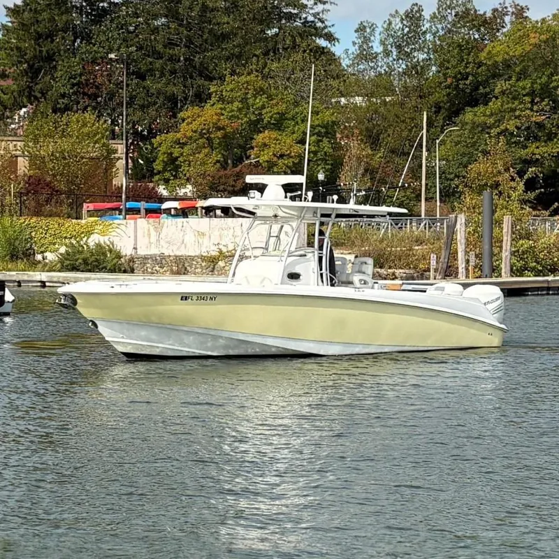 The Image of 2008 Boston Whaler 320 Outrage boat docked on a calm river with lush greenery. - 0