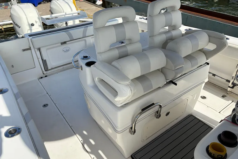 Slide: The Image of 2008 Boston Whaler 320 Outrage boat interior with cushioned seating and storage compartments. - 16