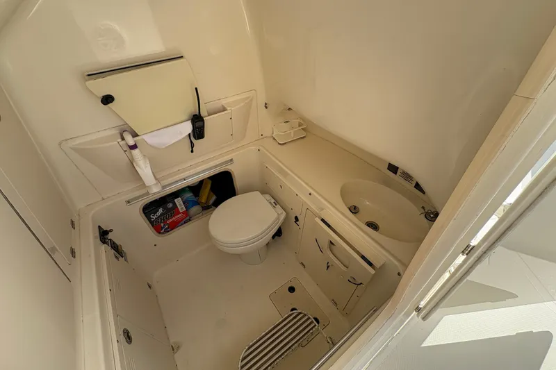 Slide: The Image of 2008 Boston Whaler 320 Outrage boat bathroom with toilet, sink, and storage. - 20