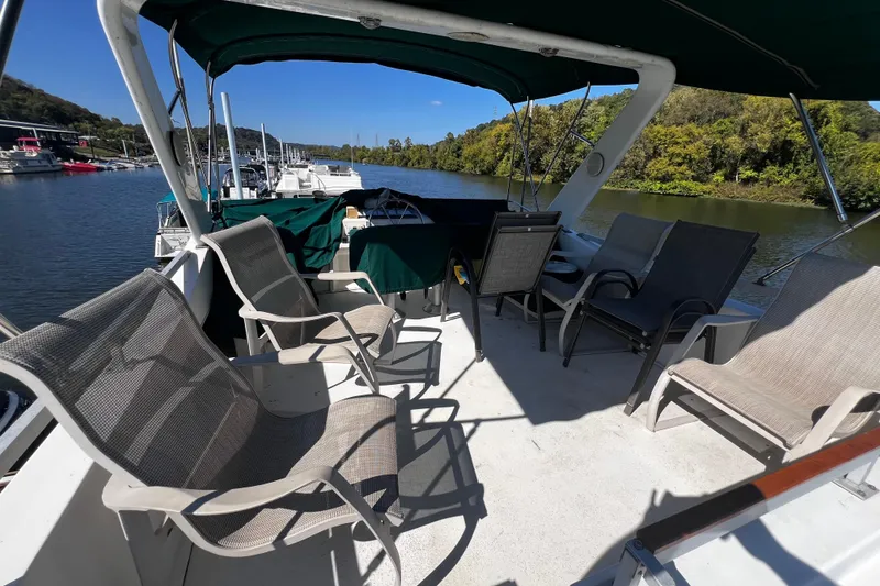 Slide: The Image of Spacious deck of 1994 Gibson 44 Classic boat with chairs and scenic river view. - 10