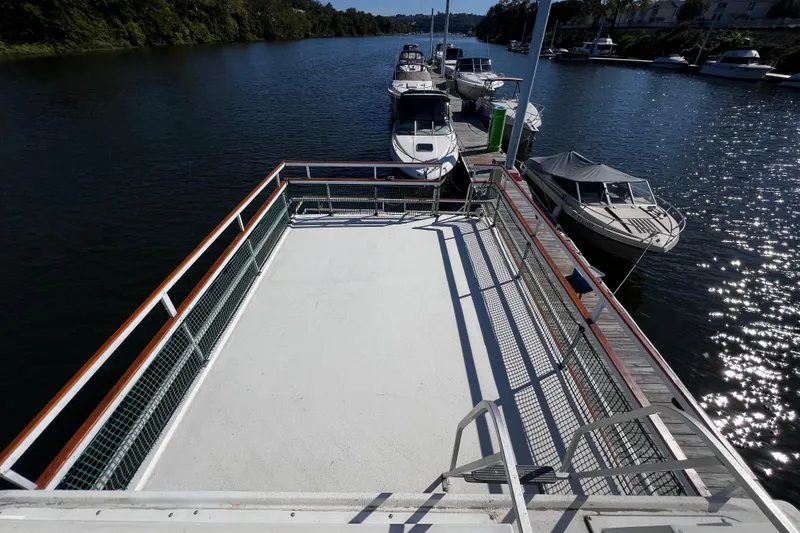 Slide: The Image of Upper deck view of a 1994 Gibson 44 Classic houseboat docked by a serene river. - 11
