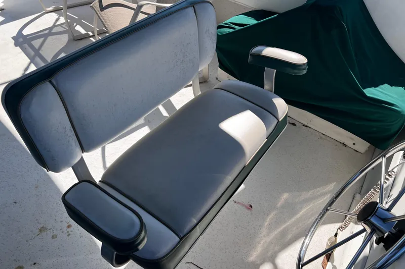 Slide: The Image of Boat seating on a 1994 Gibson 44 Classic, featuring cushioned armrests and a steering wheel. - 13
