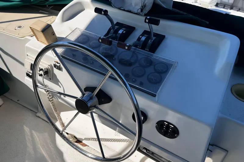 Slide: The Image of Steering wheel and controls of a 1994 Gibson 44 Classic boat. - 14
