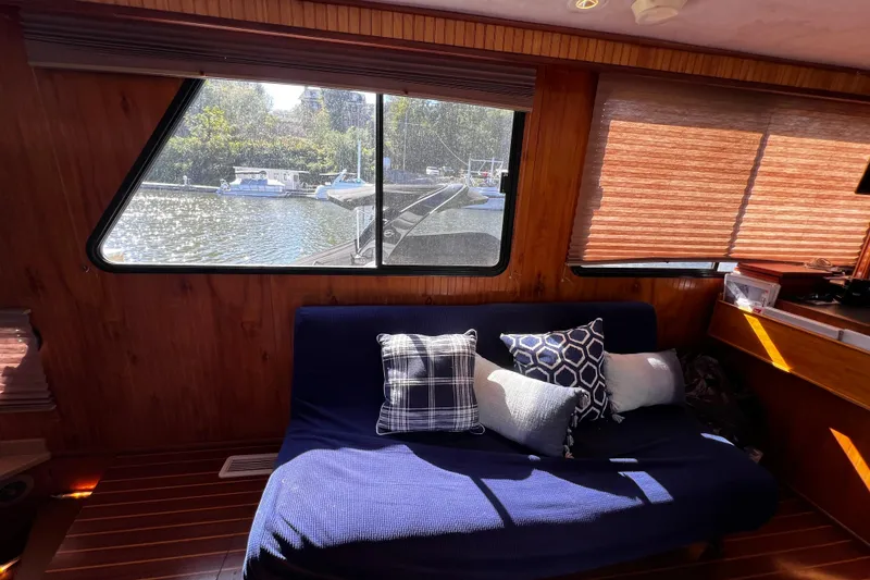Slide: The Image of Interior of 1994 Gibson 44 Classic boat with cozy seating and scenic window view. - 18