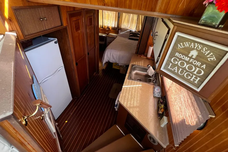 Slide: The Image of Interior of a 1994 Gibson 44 Classic boat with kitchen and cozy bedroom. - 19