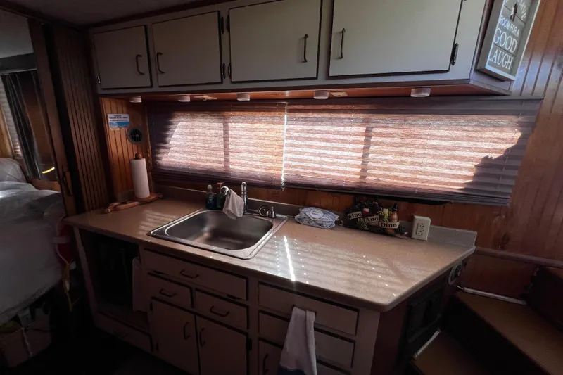 Slide: The Image of Kitchen area in a 1994 Gibson 44 Classic boat with sink and cabinets. - 21