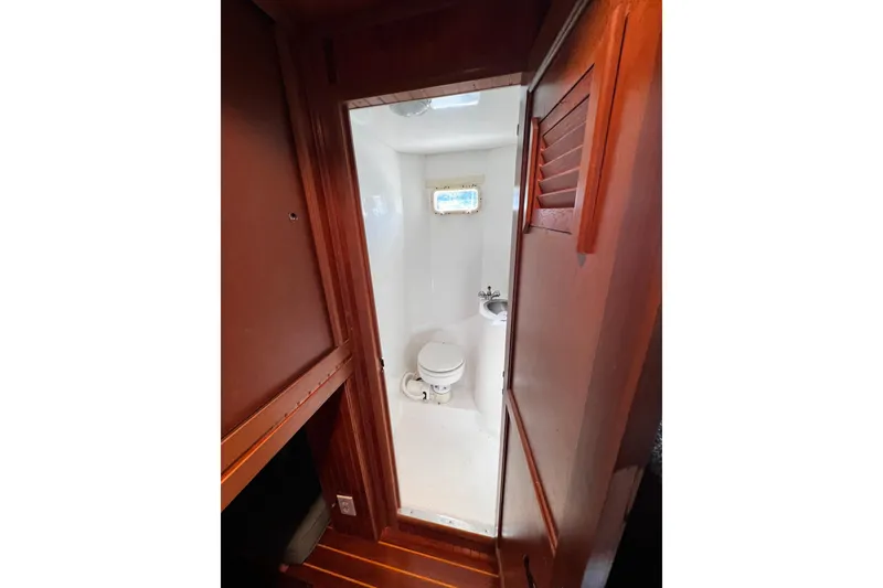 Slide: The Image of 1994 Gibson 44 Classic boat bathroom with wooden door and compact design. - 26
