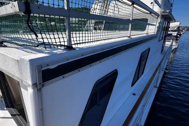 Slide: The Image of Side view of a 1994 Gibson 44 Classic boat docked on calm water. - 6