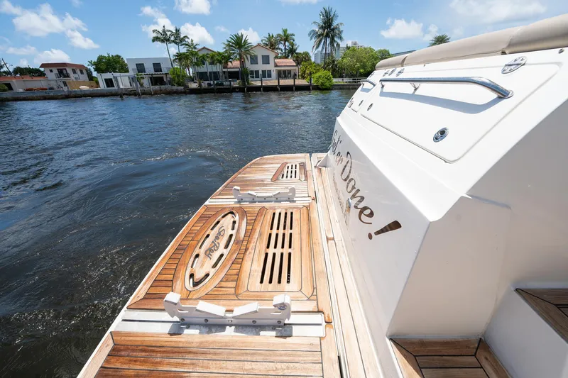 Slide: The Image of 2016 Sea Ray 510 Fly yacht with wooden deck, docked by waterfront homes. - 11