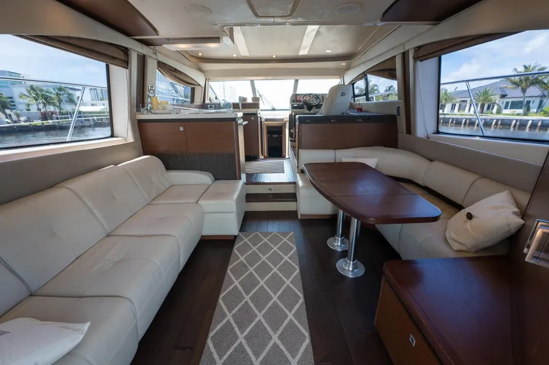 Slide: The Image of Luxurious interior of 2016 Sea Ray 510 Fly yacht with leather seating and wooden table. - 14
