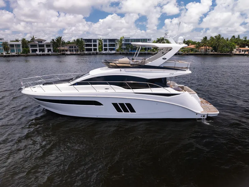 Slide: The Image of 2016 Sea Ray 510 Fly yacht on water with modern homes in background. - 4