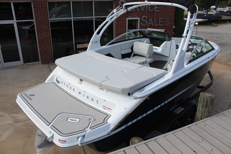 Slide: The Image of 2026 Four Winns H2 Freedom boat, sleek design, white upholstery, displayed at dealership. - 3